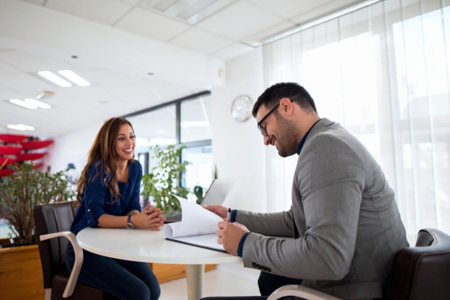 Moderne Arbeitsplätze in einem hellen Büro mit Finanzdiagrammen an der Wand